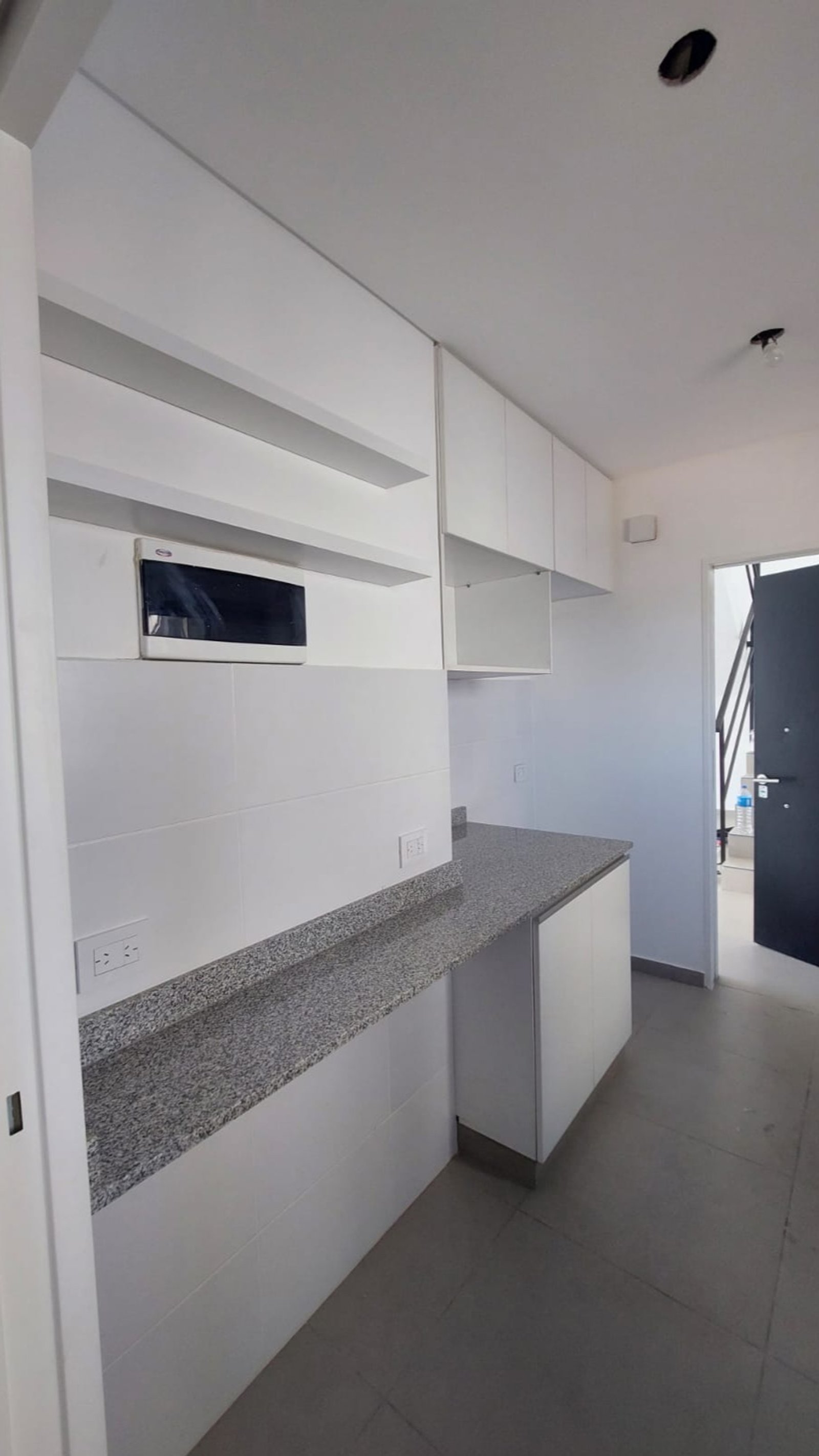 Cocina moderna con muebles blancos y encimera de granito — proyecto BA, por Arquitecta, en B1605 Munro